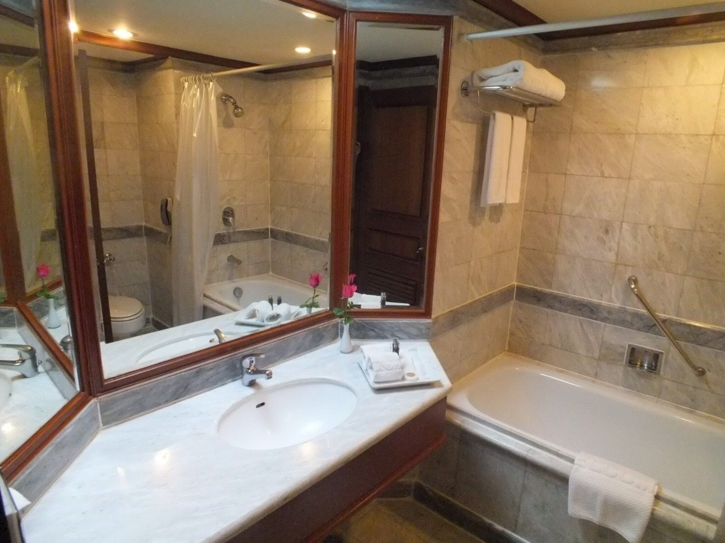 A bathroom with a marble sink, a bathtub, and a shower area.