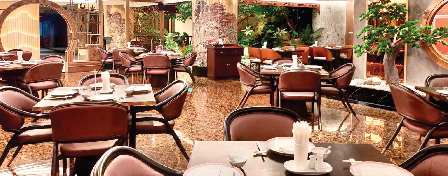 Un restaurante con varias mesas y sillas, algunas con manteles y servilletas blancos.