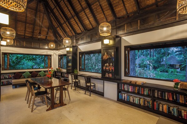 A library with bookshelves, a dining table, and chairs.