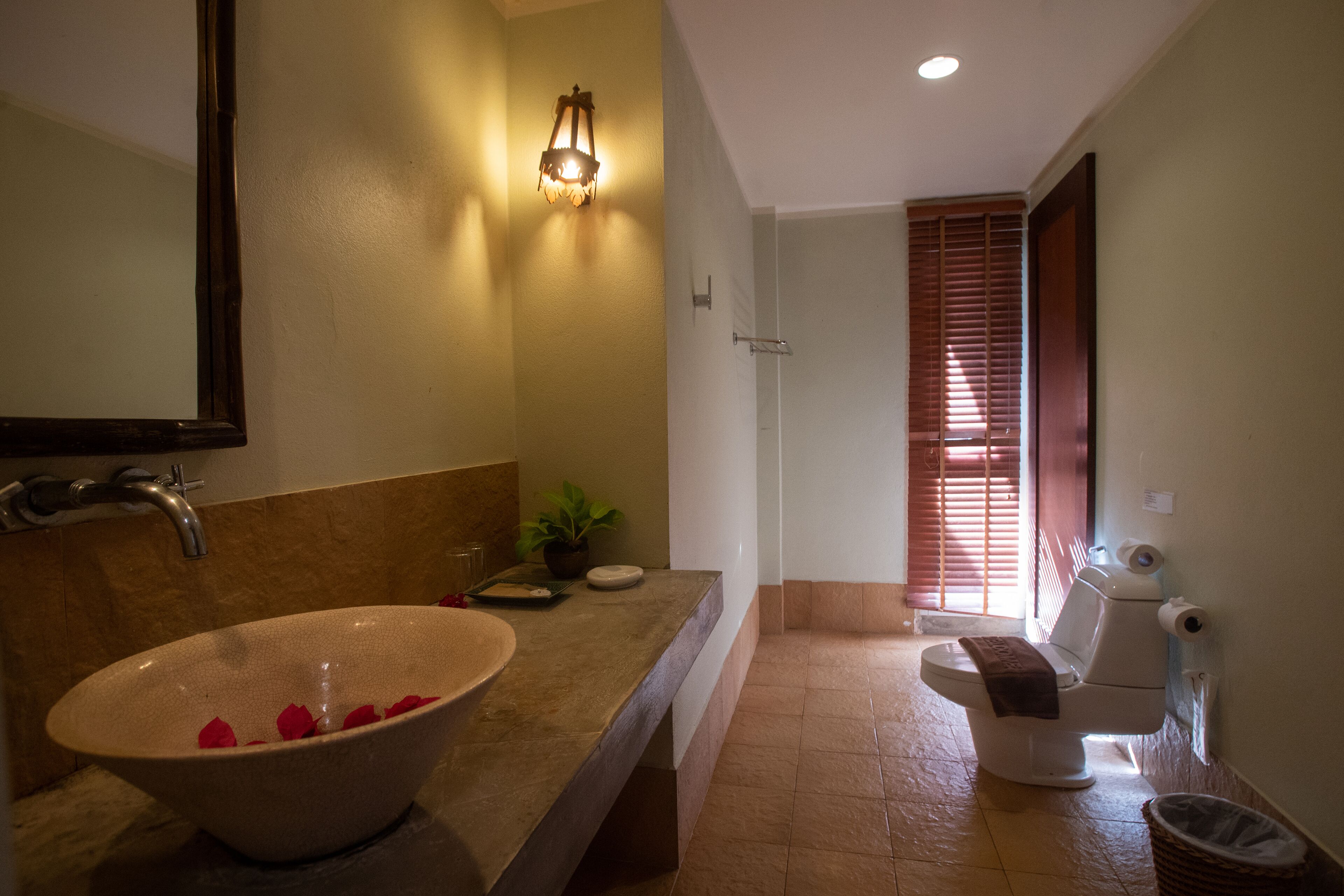 A bathroom with a large sink, a toilet, and a shower area.