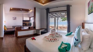 A hotel room with a bed, a TV, a desk, and a view of the beach. - Southern Lanta Resort (Ko Lanta)