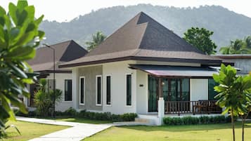 A modern two-story house with a sloped roof, large windows, and a well-maintained lawn.