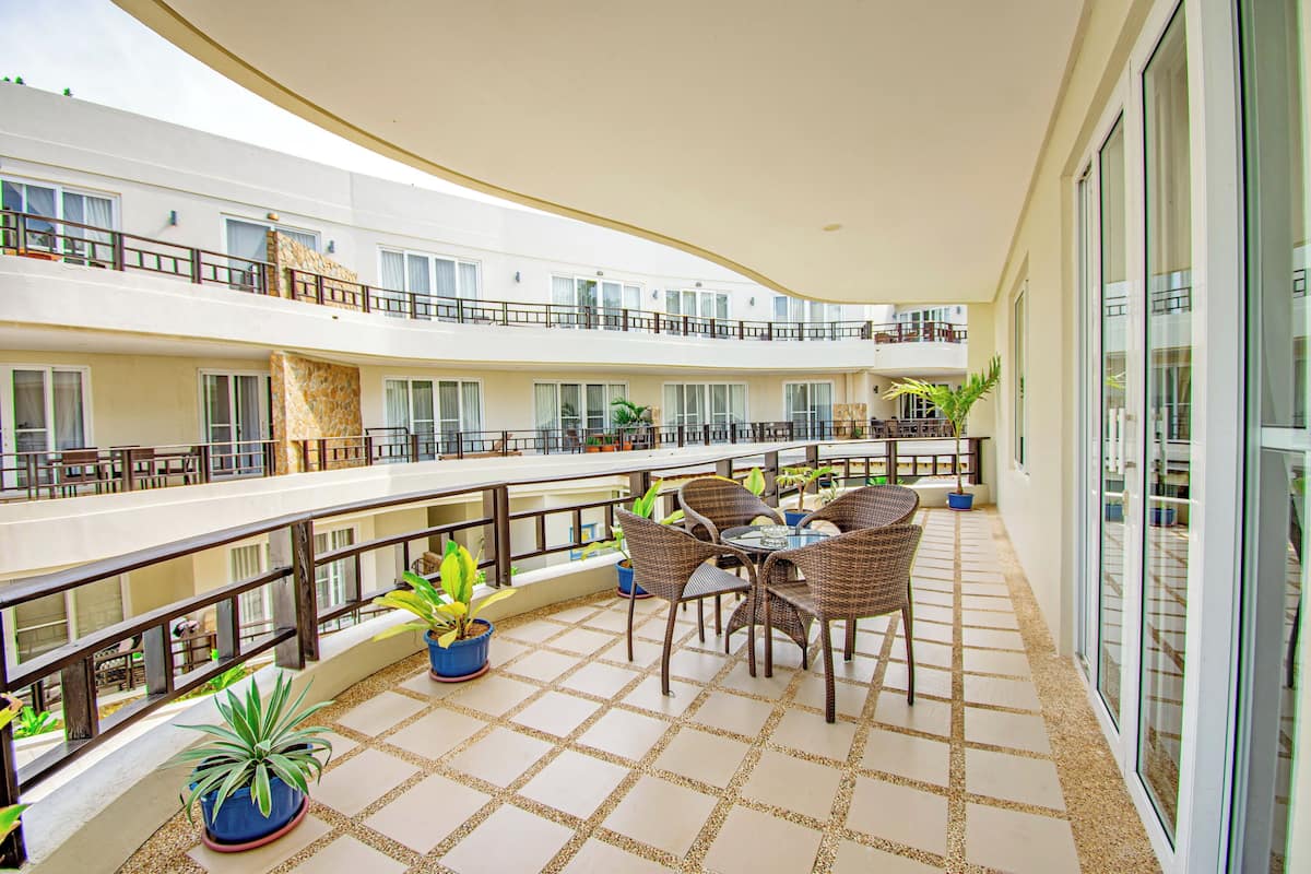 A multi-level outdoor balcony with seating and potted plants.