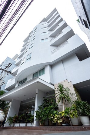 A modern building with multiple floors, balconies, and a covered entrance area with potted plants. - Club Mahindra Mac Boutique Hotel  (Bangkok)