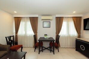 A modern living room with a dining table, chairs, a sofa, and a TV. - Club Mahindra Mac Boutique Hotel  (Bangkok)