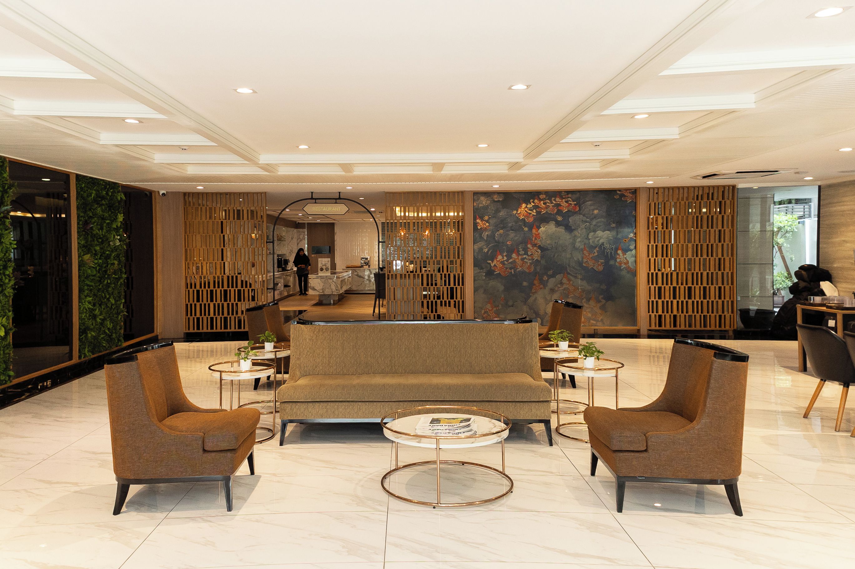 Un hall d’entrée moderne avec un canapé, des fauteuils et une table basse.