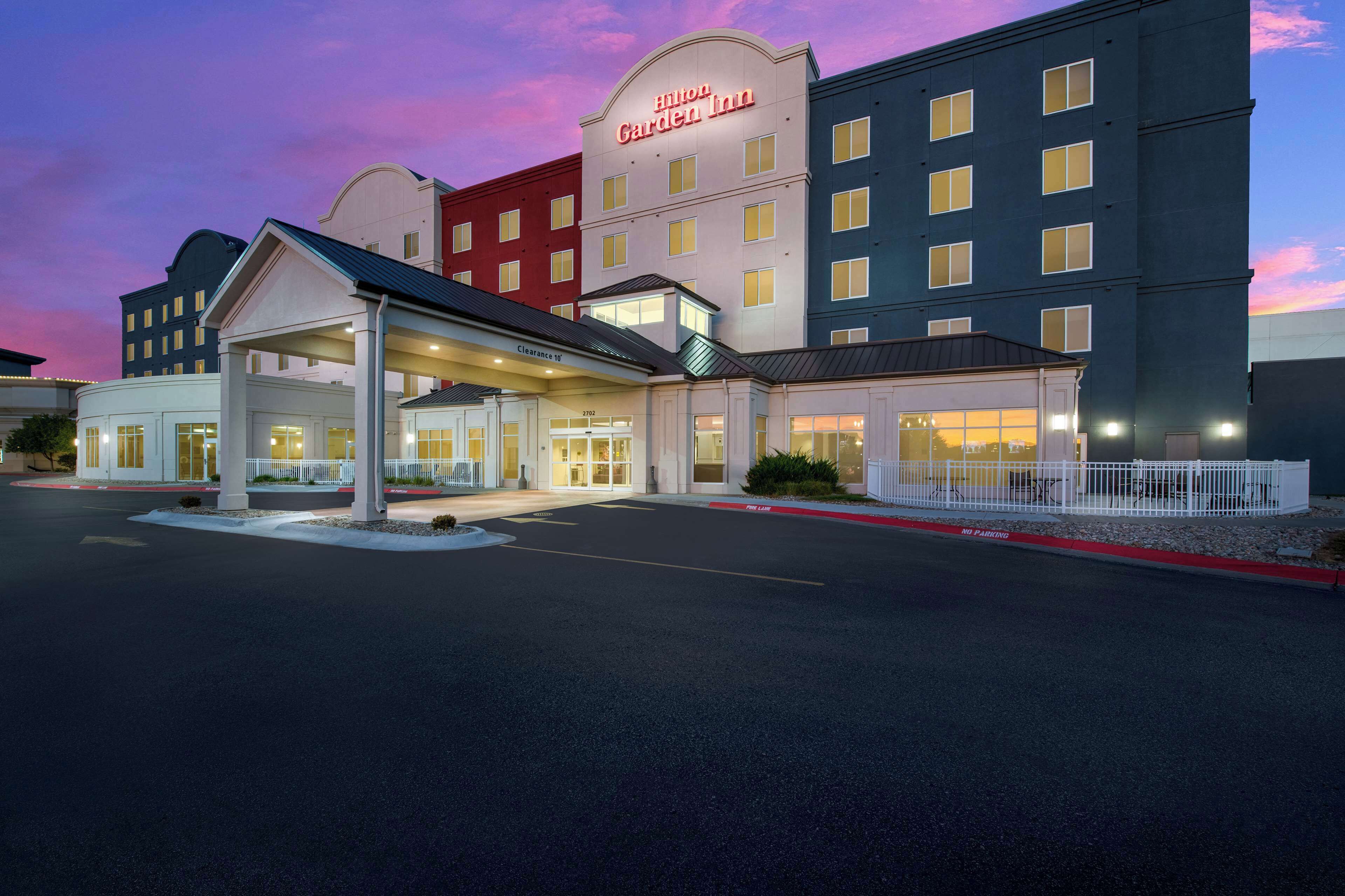 A multi-story hotel with a prominent entrance and a covered parking area.