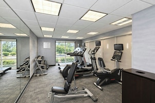 A fitness center with treadmills, elliptical machines, and weight benches.