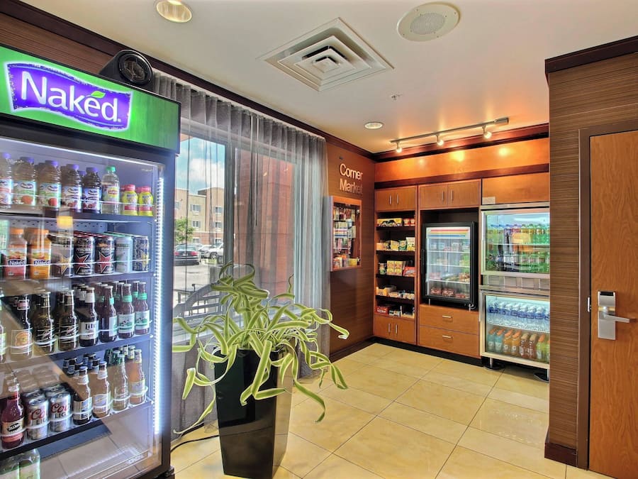 A corner market with a Naked beverage cooler, a Corner Market sign, and a refrigerator stocked with snacks.