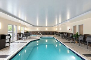 Una piscina con solárium, sillas de descanso y zona para tomar el sol.
