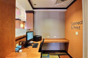 A small office area with a desk, computer, printer, and a wall sign that reads "Connect & Print".