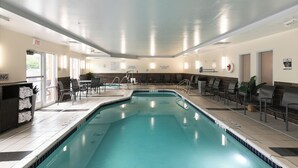 An indoor swimming pool with clear signage, a lifeguard chair, and a seating area with chairs and tables. - Fairfield Inn & Suites by Marriott Milwaukee Airport (Oak Creek)