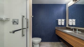 Un baño moderno con ducha, inodoro y lavamanos.