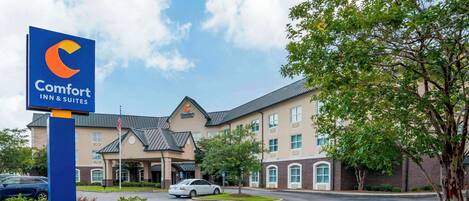 A Comfort Inn & Suites hotel with a modern design, featuring a large sign, a parking lot, and a well-maintained lawn.