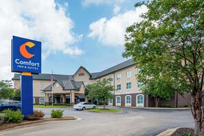 Ein Comfort Inn & Suites Hotel mit modernem Design, ausgestattet mit einer großen Schautafel, einem Parkplatz und einem gepflegten Rasen.