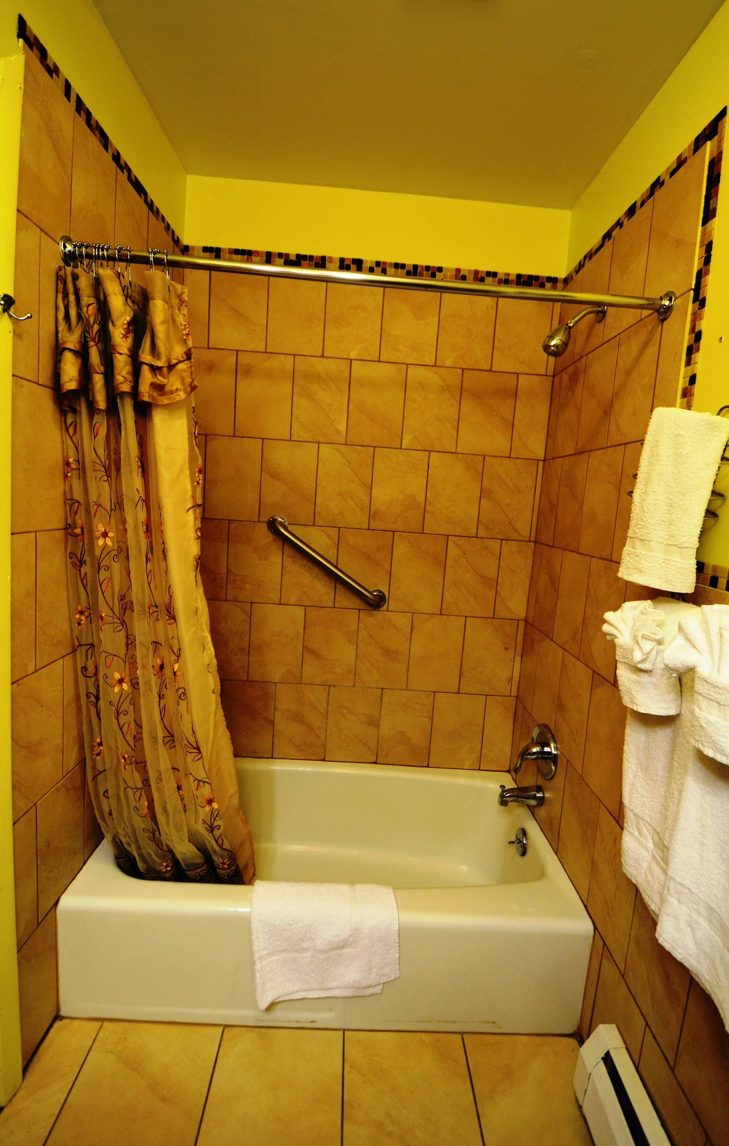 Un baño con bañera, cortina de ducha y un perchero.