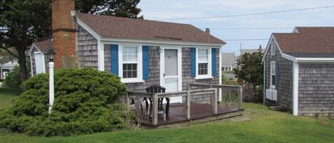A two-story house with a front porch, a chimney, and a well-maintained lawn.