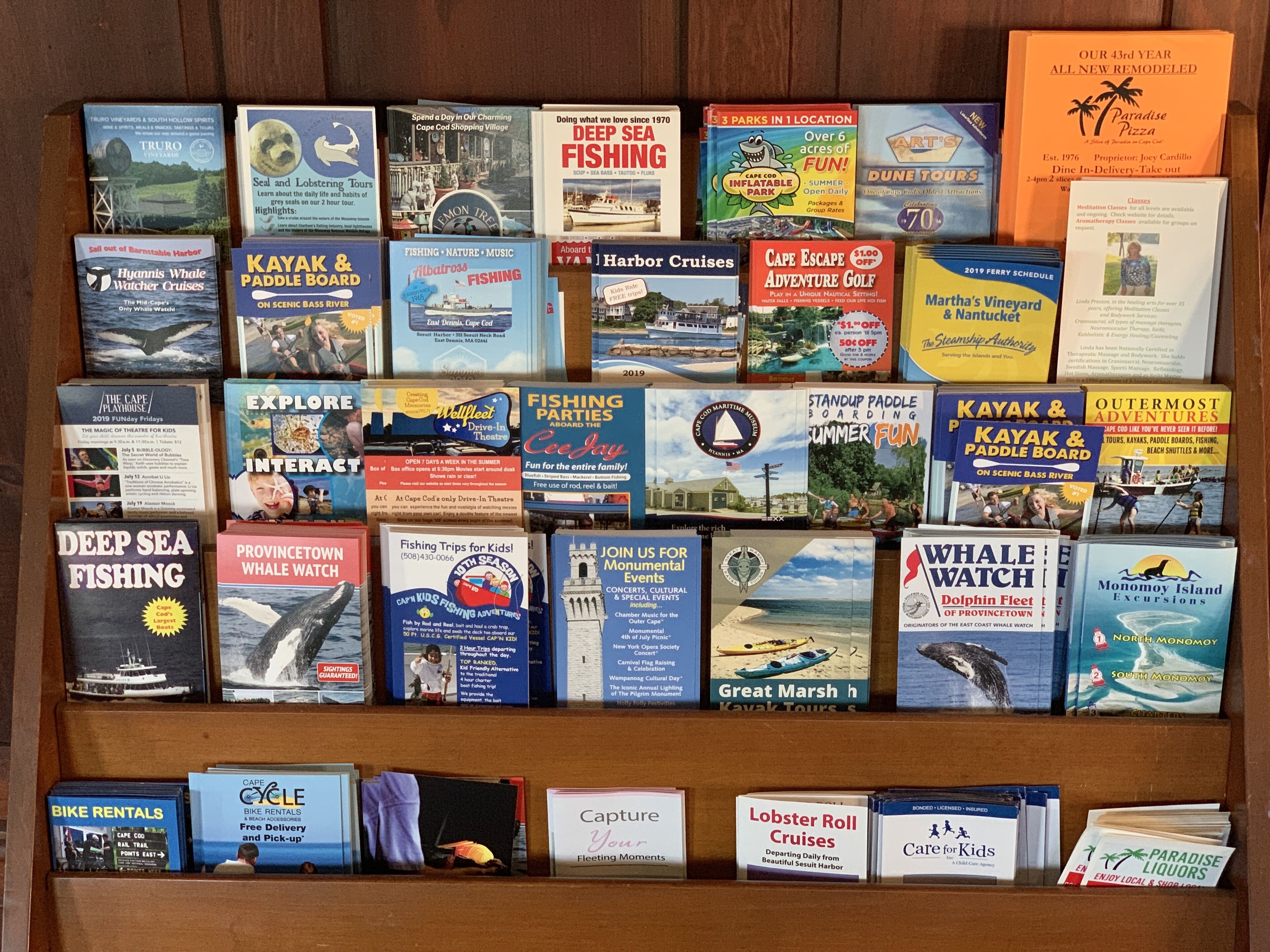 Una colección de folletos y guías de viaje sobre la región de Cape Cod, con actividades como avistamiento de ballenas, pesca y kayak.