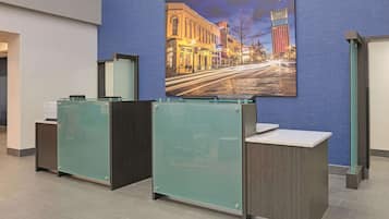 A reception area with glass partitions and a large framed cityscape picture on the wall.
