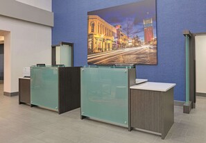 A reception area with glass partitions and a large framed cityscape picture on the wall. - La Quinta Inn & Suites by Wyndham Tyler South (Tyler)