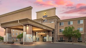 A Comfort Inn & Suites hotel with a modern architectural design, featuring a prominent entrance with a covered walkway and large planters. - Comfort Inn & Suites Brighton Denver NE Medical Center (Brighton)