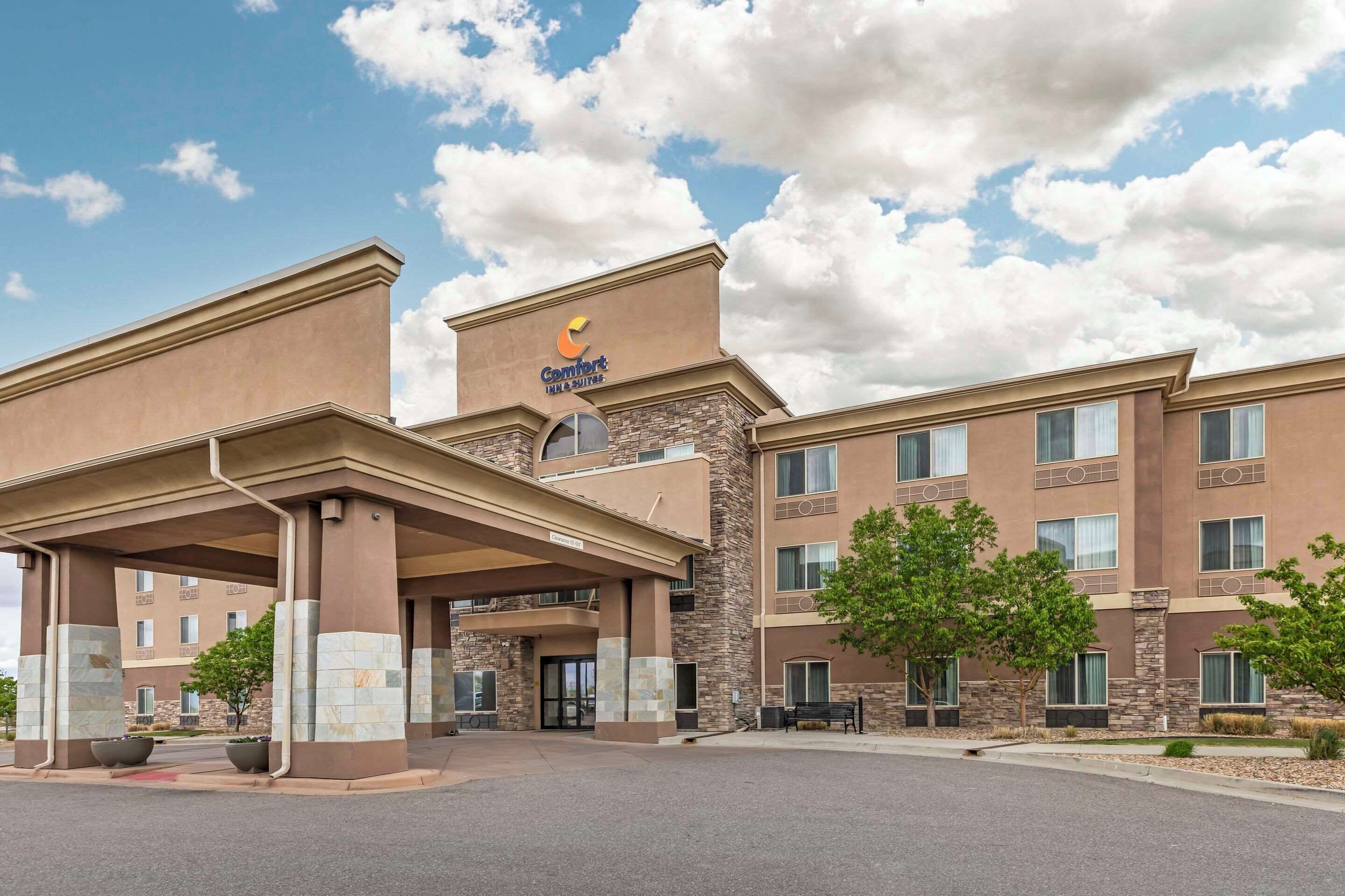 A Comfort Inn & Suites hotel with a stone facade, multiple balconies, and a covered entrance.