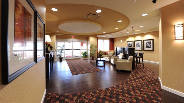 A spacious lobby with a patterned carpet, a reception desk, seating area, and framed artwork on the walls. - Hampton Inn Suites Scottsboro (Scottsboro)