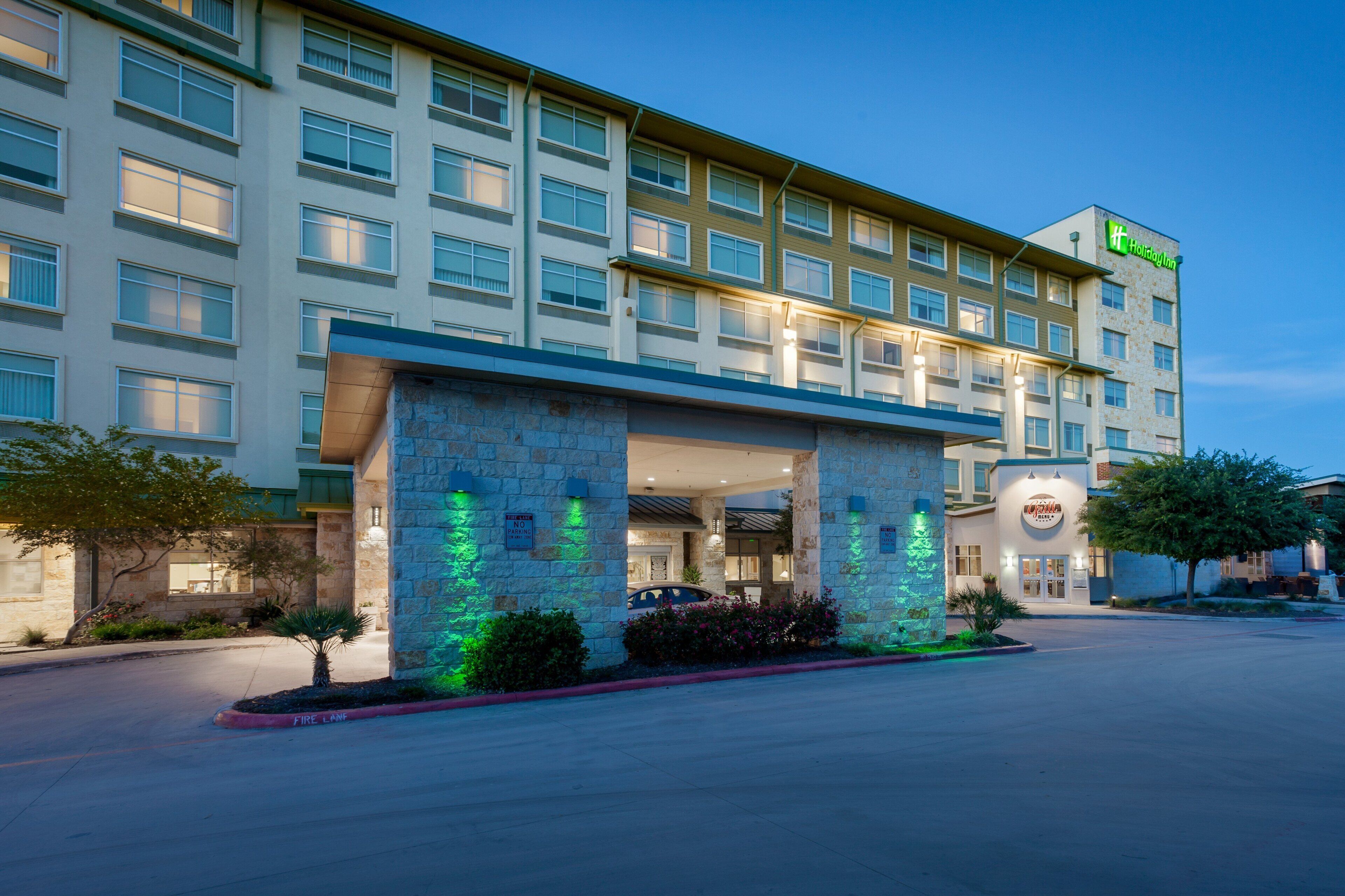 A multi-story hotel with a stone facade, a Holiday Inn sign, and a restaurant named 'Grille.'
