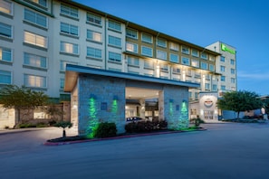 Un hôtel à plusieurs étages, doté d’une façade en pierre, d’une enseigne Holiday Inn et d’un restaurant appelé « Grille ».
