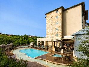 Un hôtel doté d’une piscine, d’un espace extérieur aménagé et d’un bâtiment en pierre.