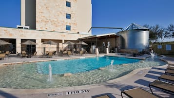 Una piscina techada, una piscina al aire libre, sombrillas