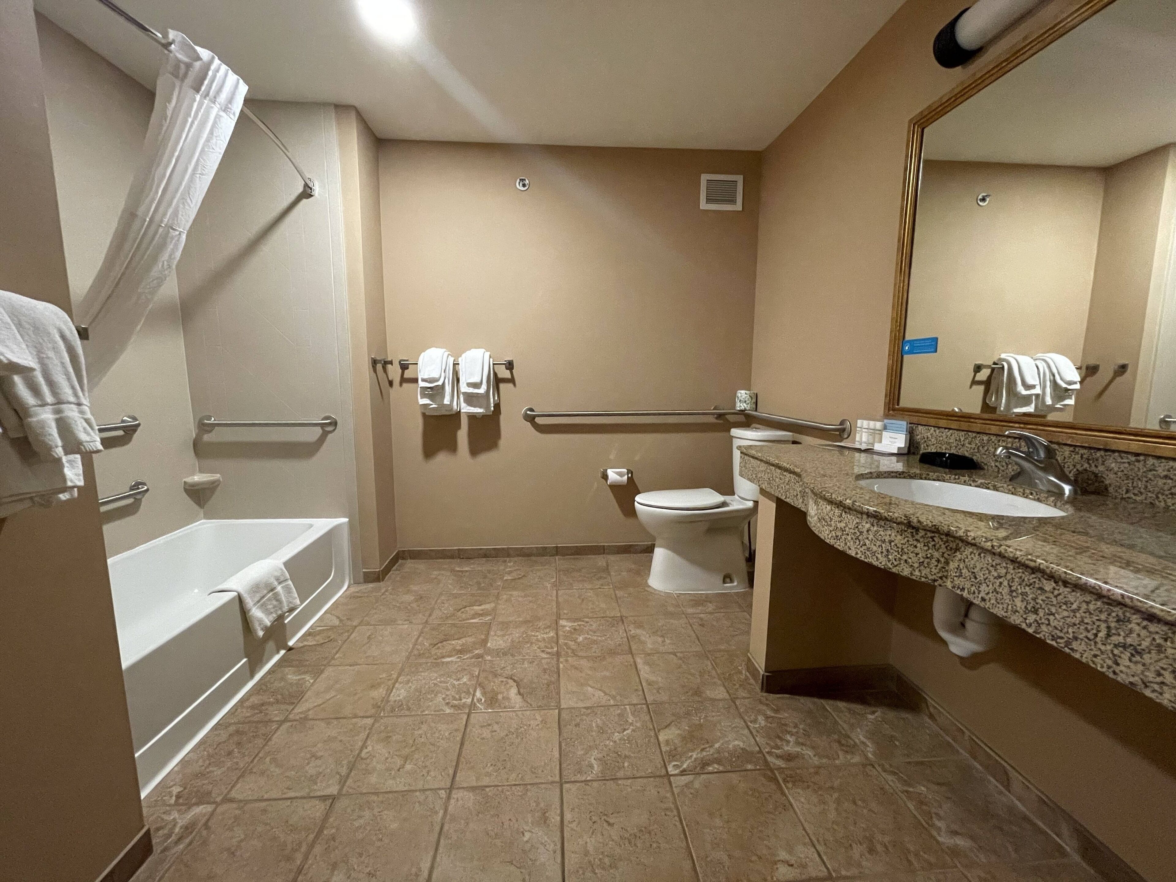 Un baño con bañera, inodoro y lavamanos.