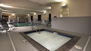 A swimming pool area with a tiled floor, a pool with a blue border, and a sign with rules. - Hampton Inn Defiance (Defiance)