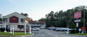 A Country View Inn & Suites with a two-story building, a parking lot, and a welcoming sign.