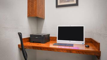 A wooden desk with a Dell computer, a keyboard, a mouse, and a printer.