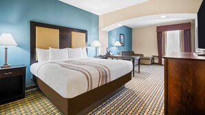 Habitación de hotel con una cama grande, dos mesitas de noche, un escritorio y una silla.