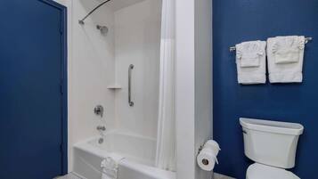 A bathroom with a bathtub, toilet, and a shower curtain.