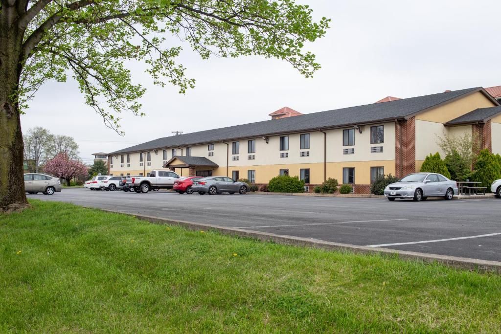 A multi-story building with a parking lot in front.