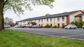 A multi-story building with a parking lot in front.