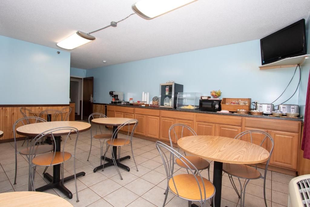 A kitchen with wooden cabinets, a microwave, a toaster, and a television mounted on the wall.