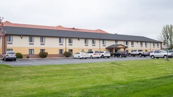 Un hotel a più piani con un parcheggio antistante.