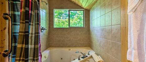 Une salle de bain avec une baignoire, une fenêtre et un rideau de douche.
