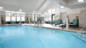 A large indoor swimming pool with multiple lounge chairs and a lifeguard stand. - Residence Inn by Marriott Lincoln South (Lincoln)