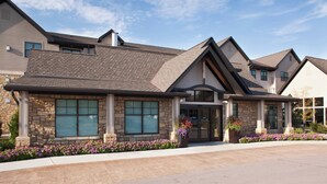 A modern building with a stone facade, large windows, and a landscaped entrance. - Residence Inn by Marriott Lincoln South (Lincoln)