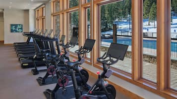 A gym with stationary bikes, treadmills, and rowing machines.