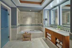 A modern bathroom with a bathtub, two sinks, and a vanity with shelves.