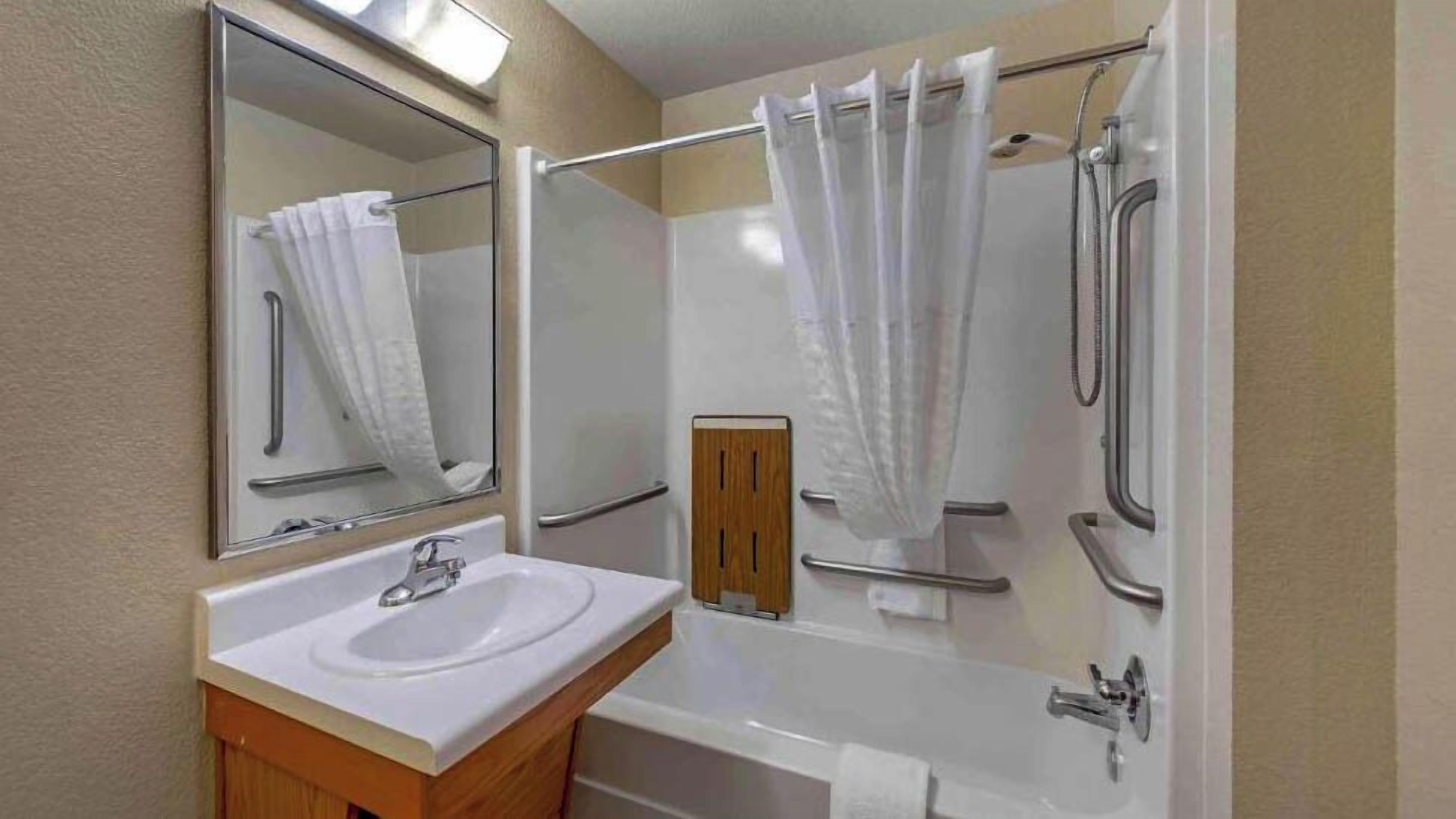 Un baño con lavabo, espejo, ducha y bañera.