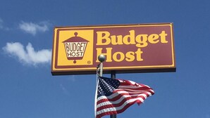 A sign for Budget Host with an American flag. - Budget Host Platte Valley Inn (Julesburg)