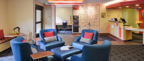 A lobby with blue seating, a reception desk, and a map on the wall.