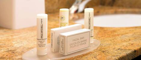 A bathroom counter with a facial bar soap dispenser and a box labeled "FACIAL BAR SAVON EN BARRE POUR LE VISAGE".